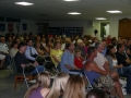 The packed club rooms watch a video of Steve